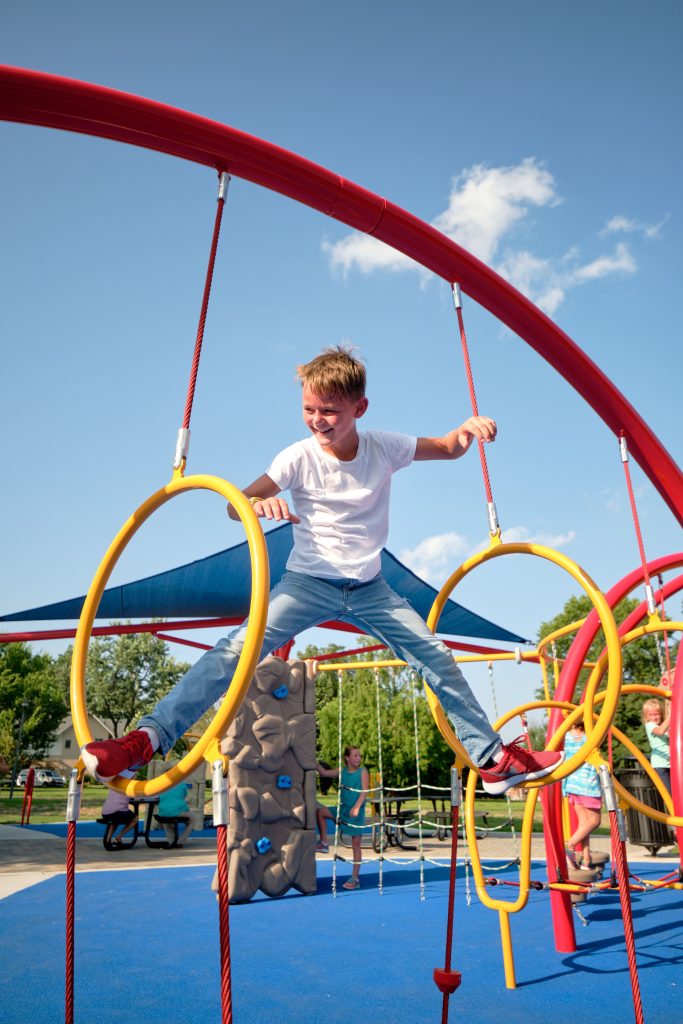 little boy standing with legs on hoop alley hoops