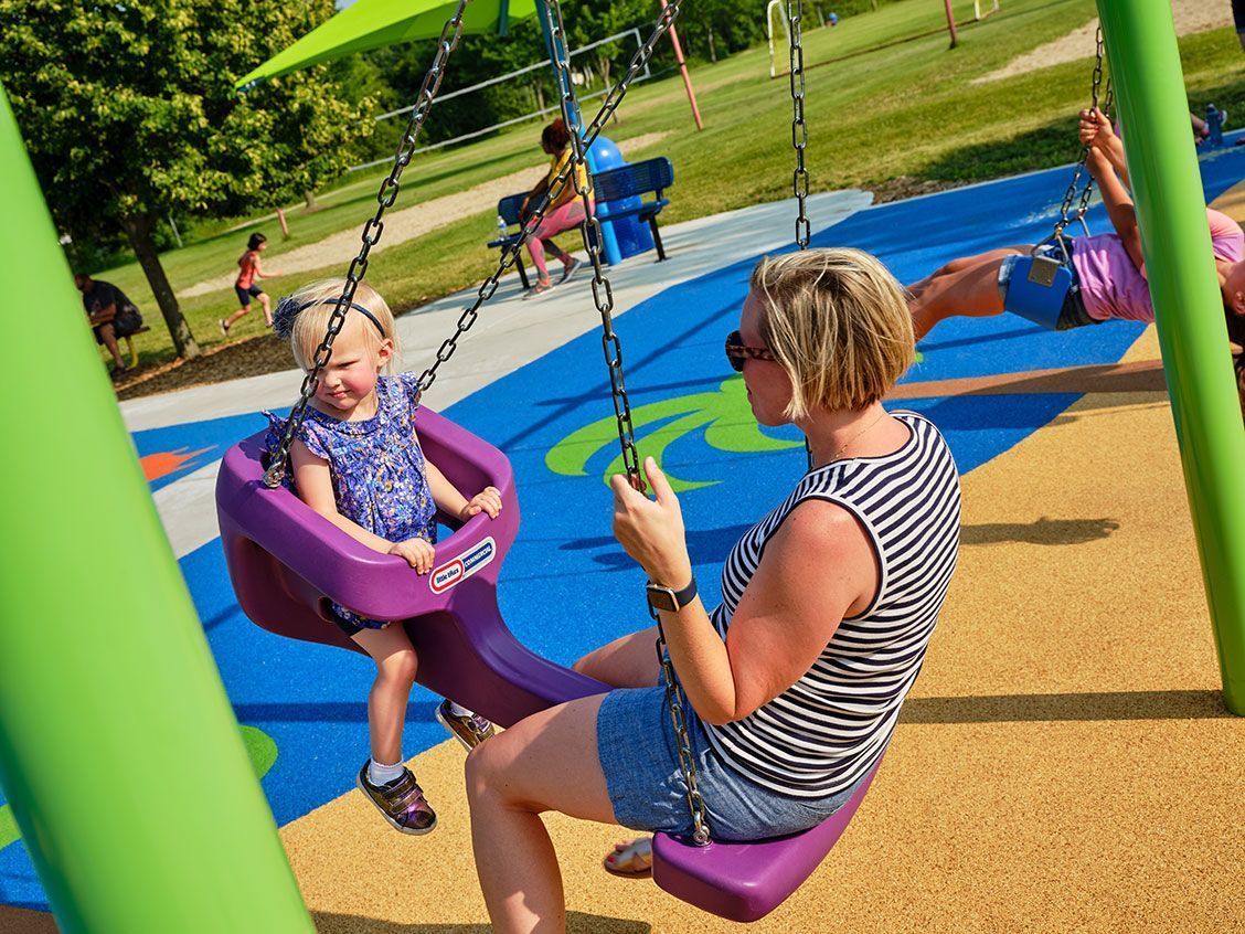 Mom and daughter on commercial playground swing