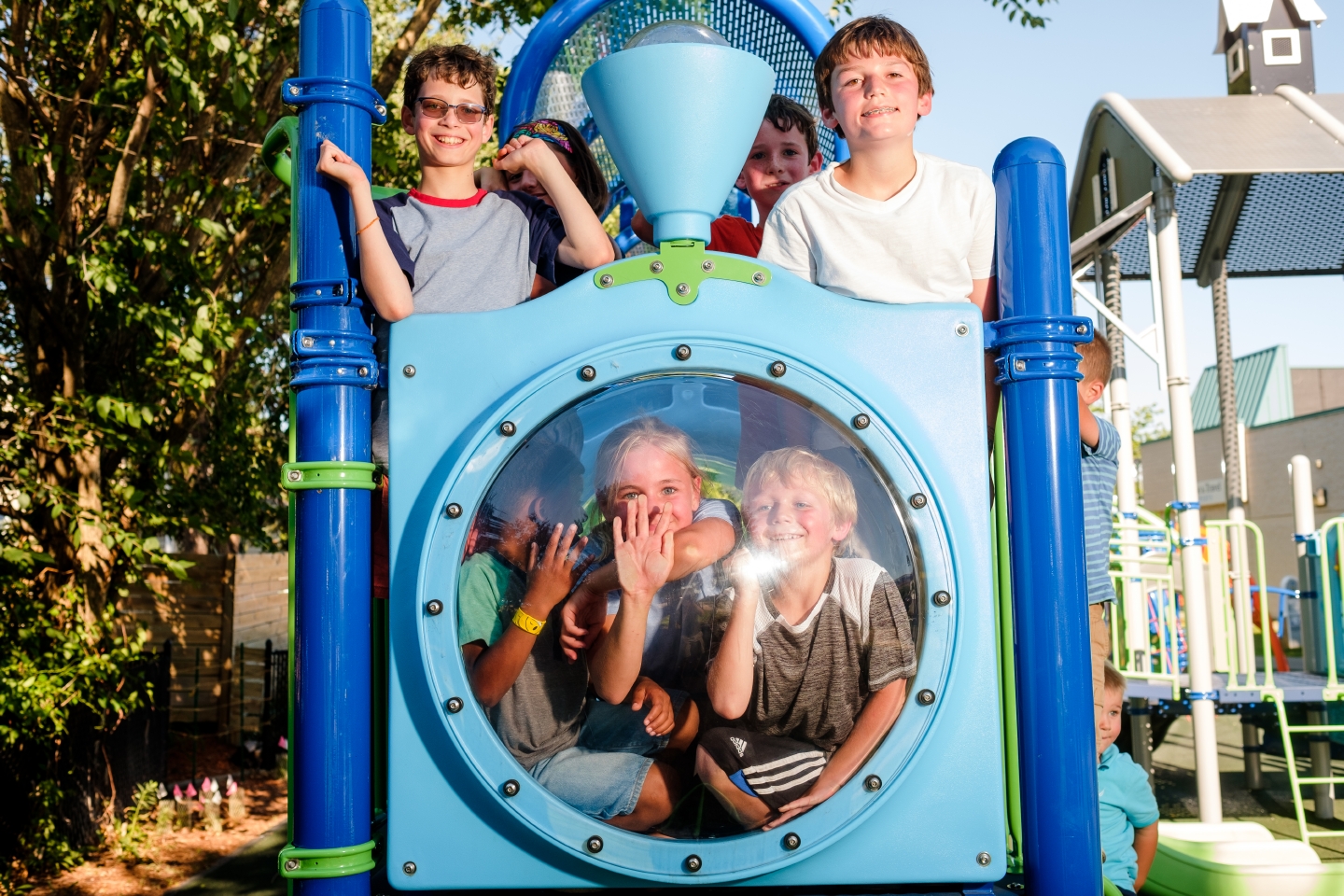 children posing for picture on playground equipment