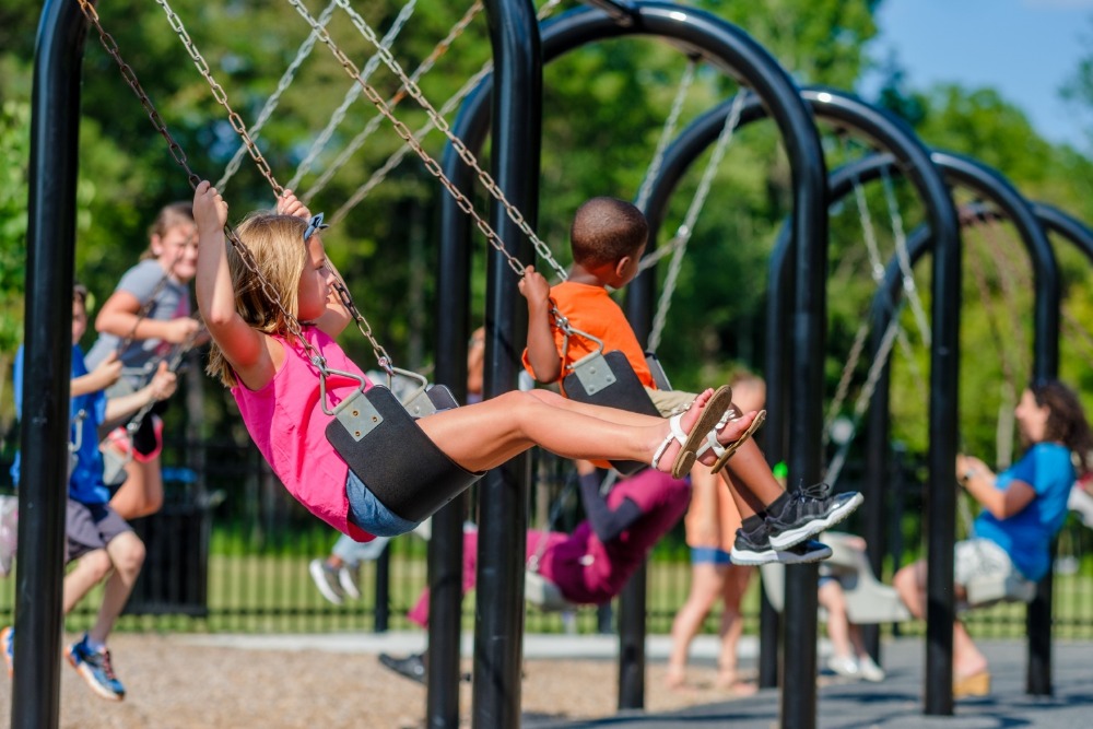 Children on commercial playground swings